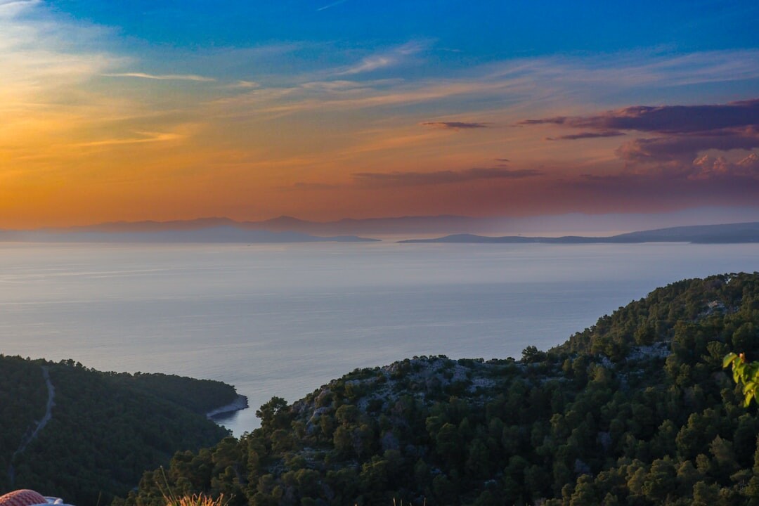 Empty sun loungers beside a boutique hotel pool in Hvar at dawn
