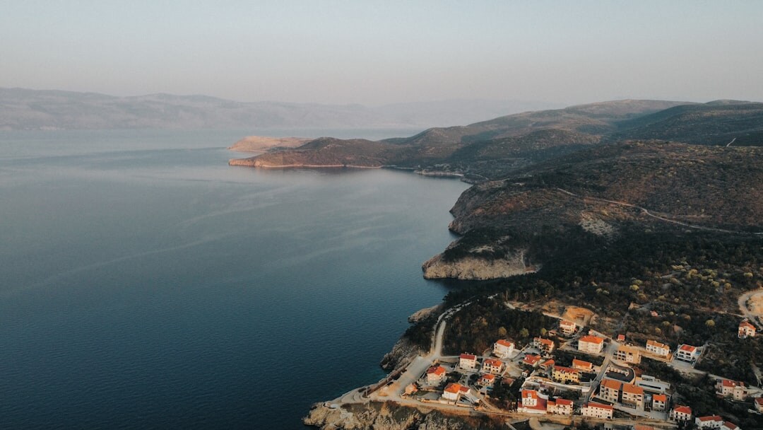 Panoramic view of the Adriatic coastline at golden hour with old stone town and terracotta rooftops