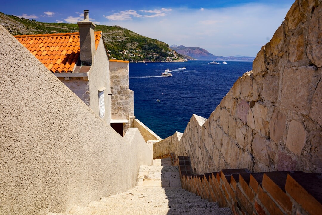 Stone staircase winding between old houses in Dubrovnik with washing lines above